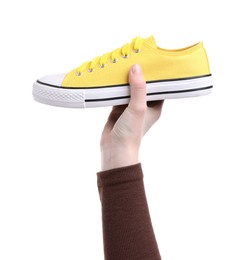 Photo of Woman with stylish yellow sneaker on white background, closeup