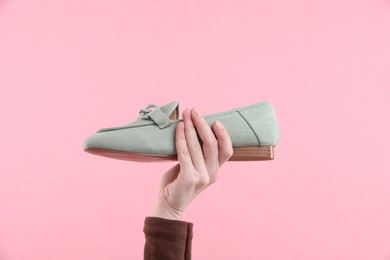 Woman with stylish shoe on pink background, closeup