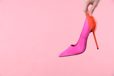 Woman with high heeled shoe on pink background, closeup. Space for text