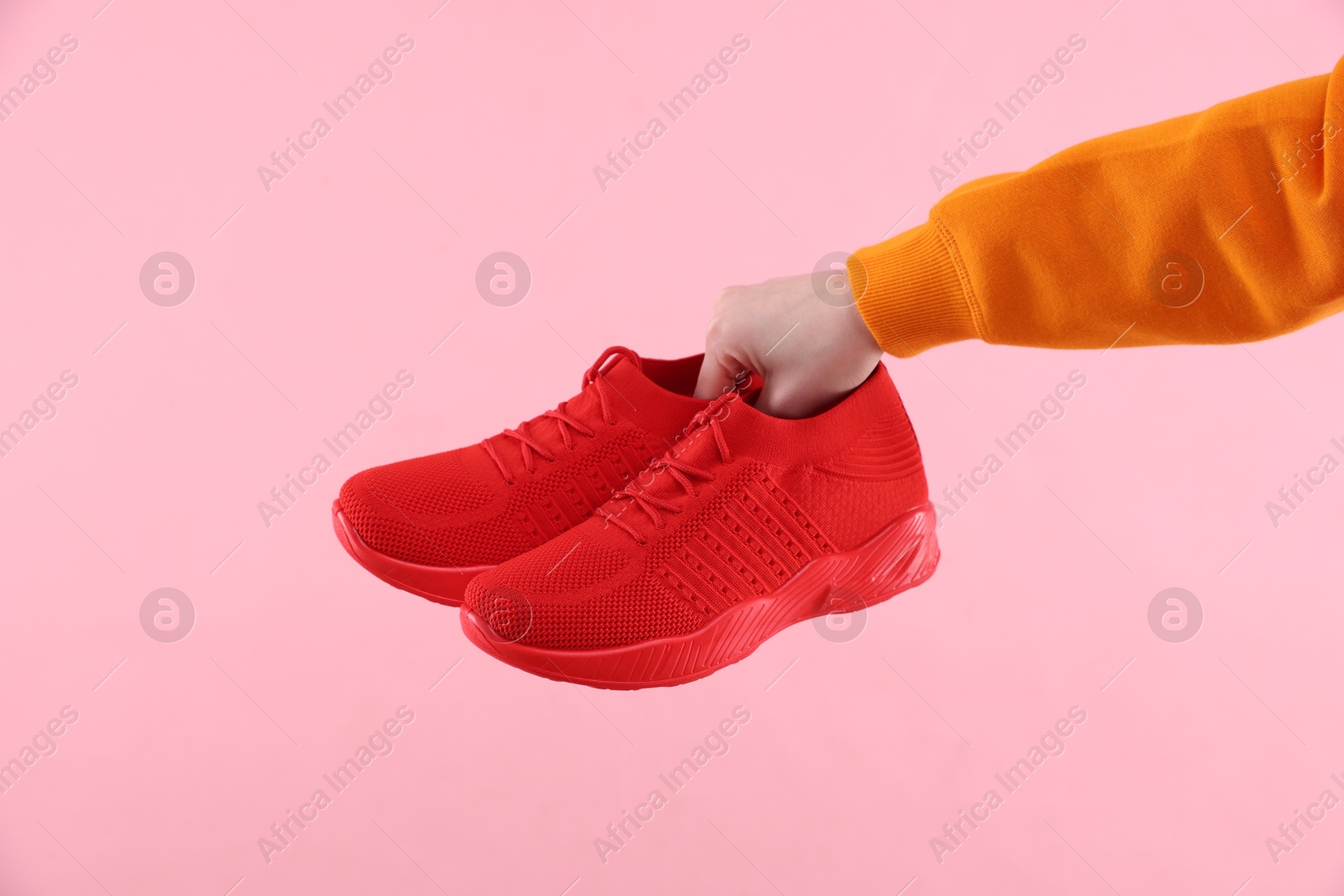 Photo of Woman with stylish sneakers on pink background, closeup