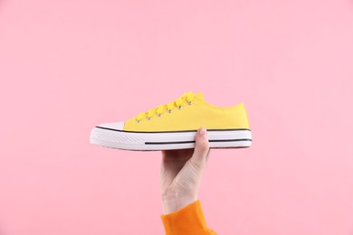 Photo of Woman with stylish sneaker on pink background, closeup