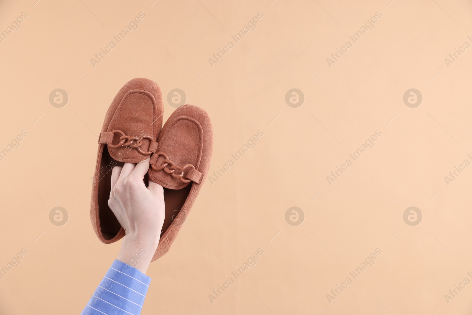 Photo of Woman with stylish shoes on beige background, closeup. Space for text