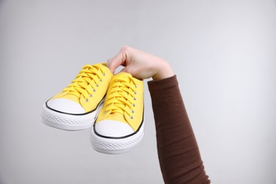 Photo of Woman with stylish sneakers on grey background, closeup