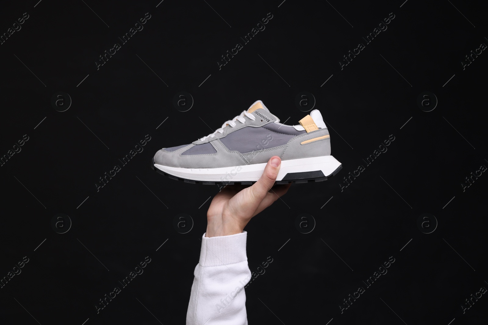 Photo of Man with stylish sneaker on black background, closeup