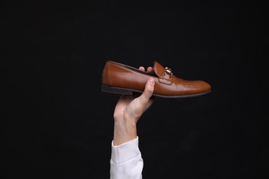 Photo of Man with stylish shoe on black background, closeup