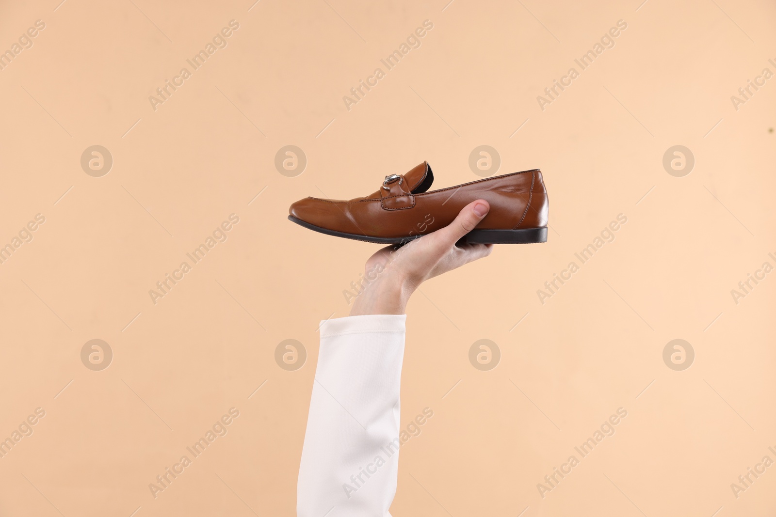 Photo of Man with stylish shoe on beige background, closeup