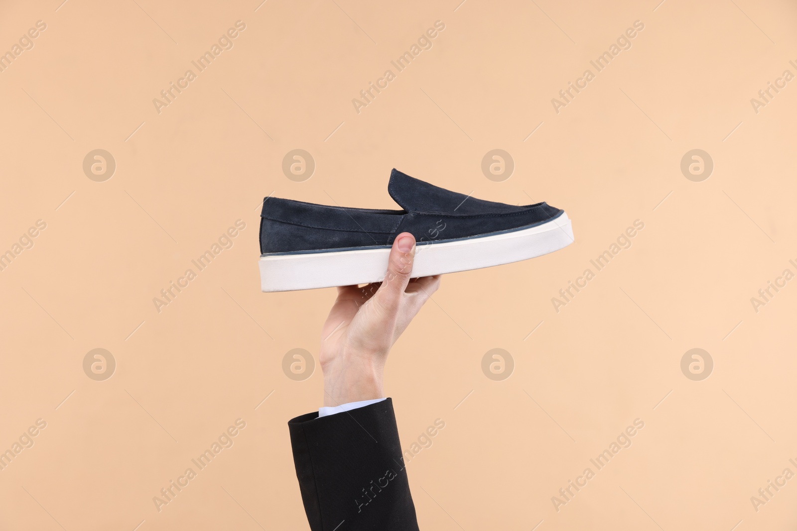 Photo of Man with stylish shoe on beige background, closeup