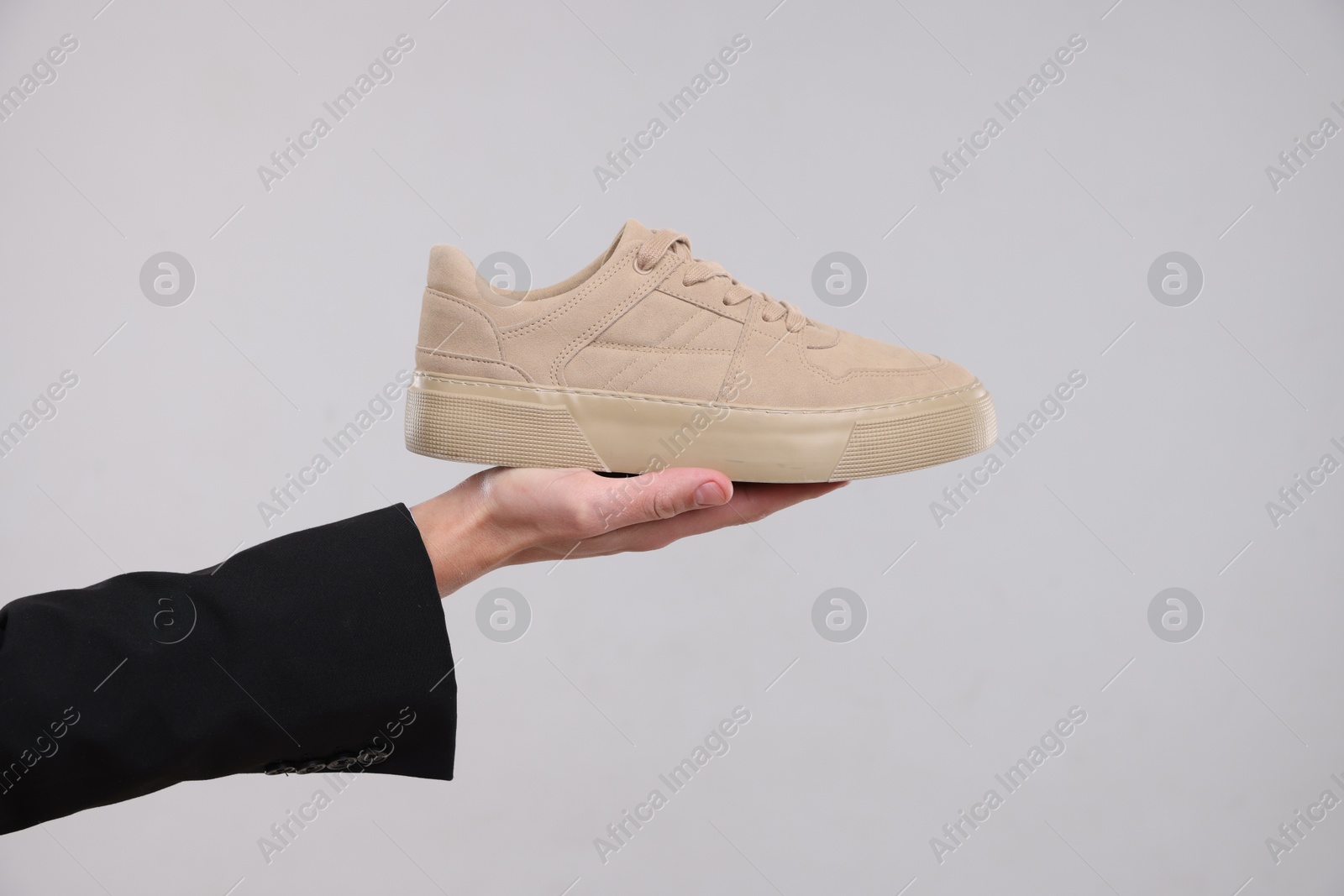 Photo of Man with stylish sneaker on grey background, closeup