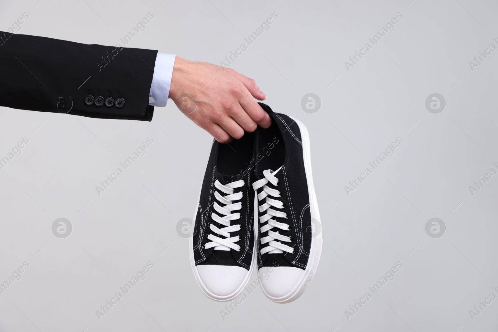 Photo of Man with stylish sneakers on grey background, closeup