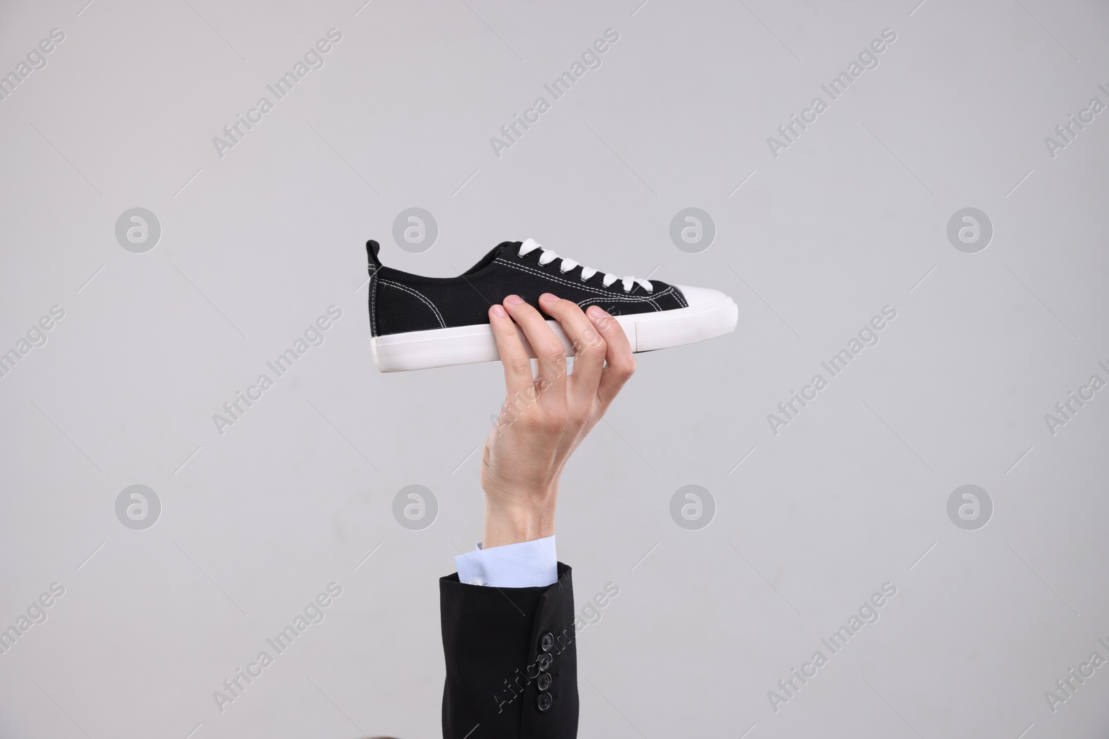 Photo of Man with stylish sneaker on grey background, closeup