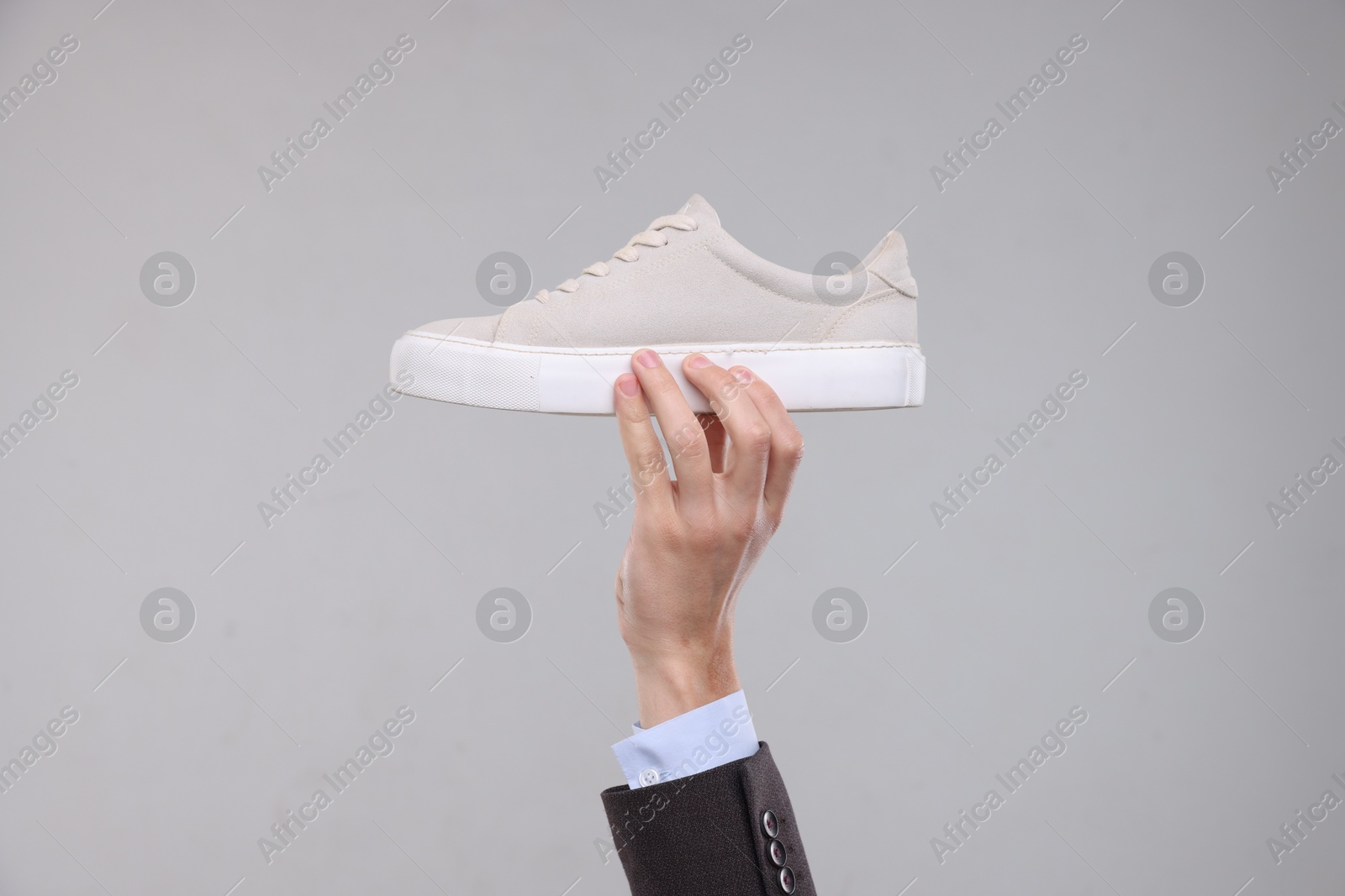 Photo of Man with stylish sneaker on grey background, closeup