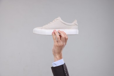 Photo of Man with stylish sneaker on grey background, closeup