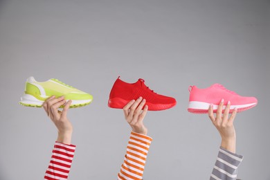 Photo of Women with different stylish sneakers on grey background, closeup