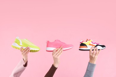 Photo of Women with different stylish sneakers on pink background, closeup. Space for text