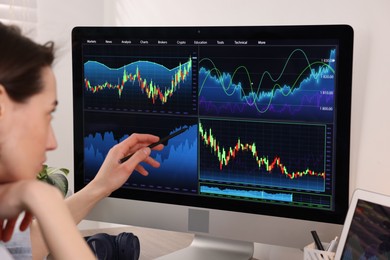 Photo of Stock exchange. Woman analysing financial market on computer indoors, closeup