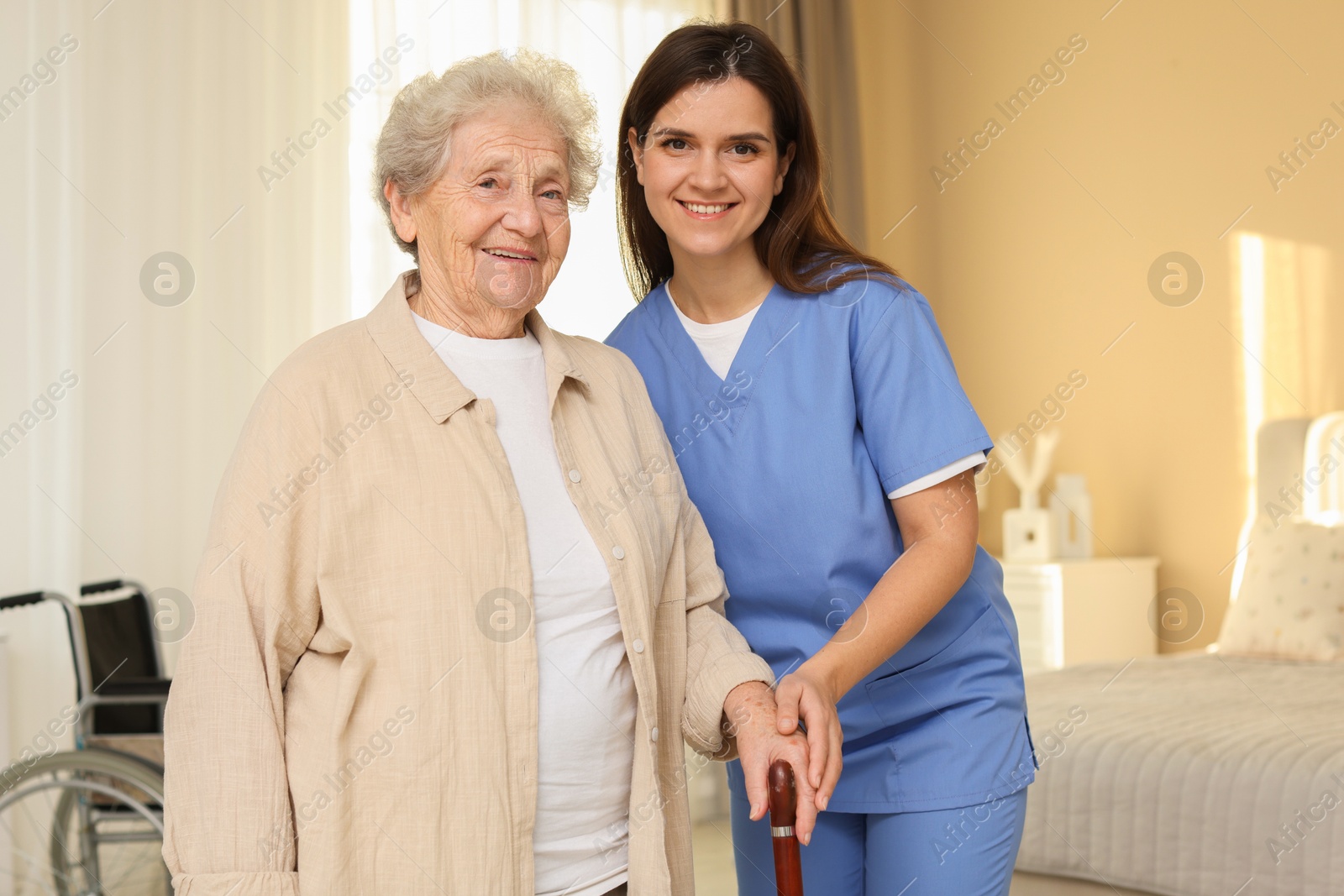 Photo of Smiling healthcare worker and elderly woman indoors