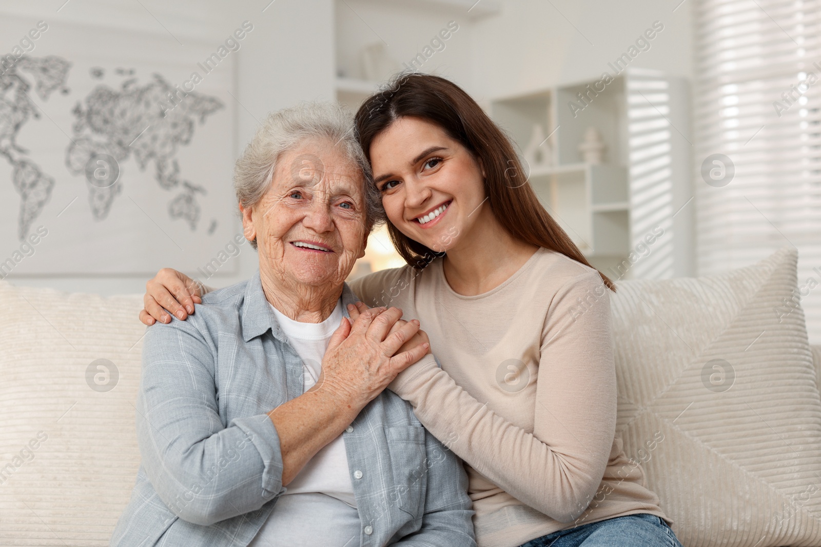 Photo of Portrait of happy granddaughter and her grandmother at home. Elderly care