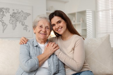 Photo of Portrait of happy granddaughter and her grandmother at home. Elderly care