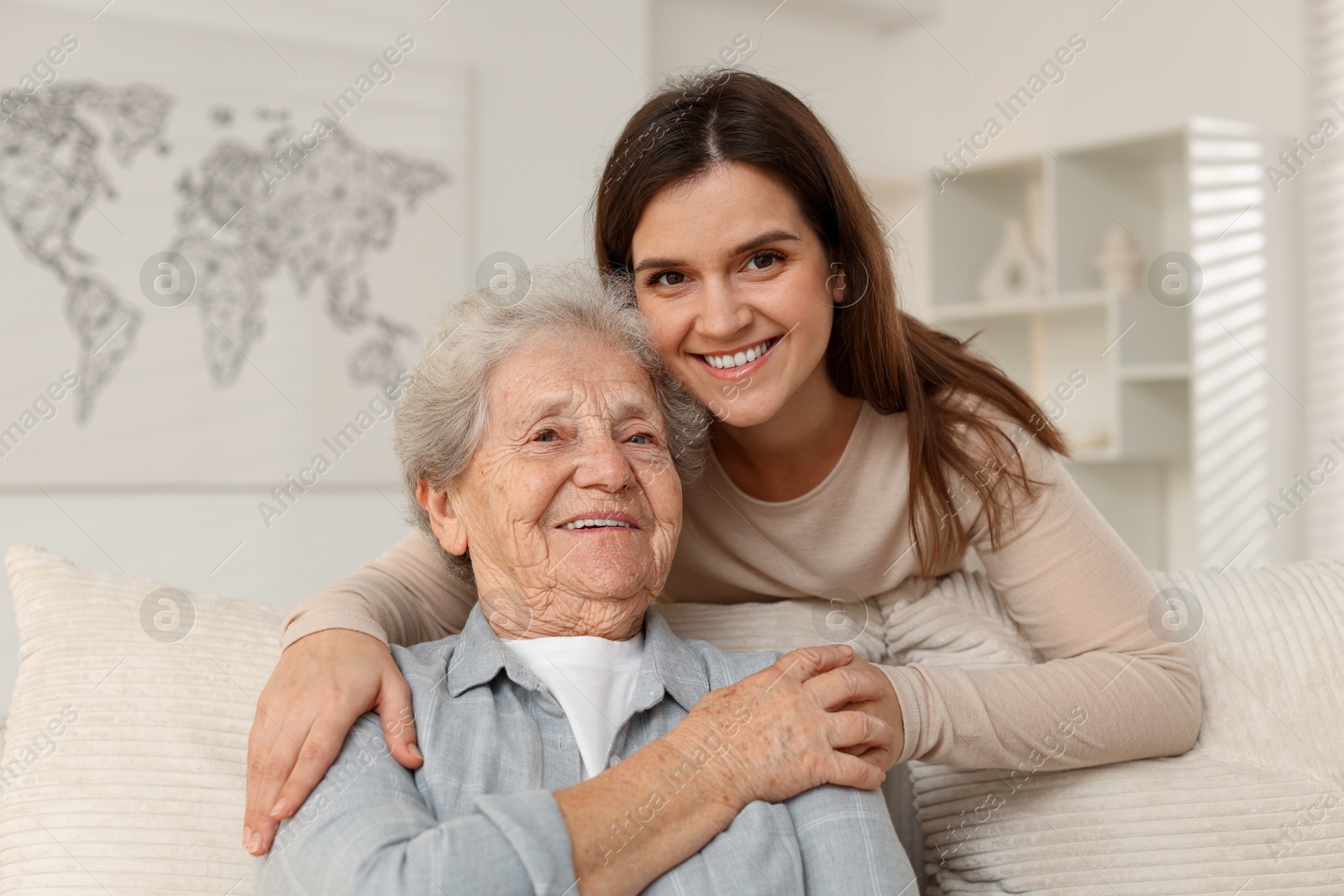 Photo of Portrait of happy granddaughter and her grandmother at home. Elderly care