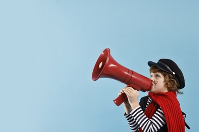 Photo of Cute boy in mime costume with megaphone on light blue background, space for text. Surprise party