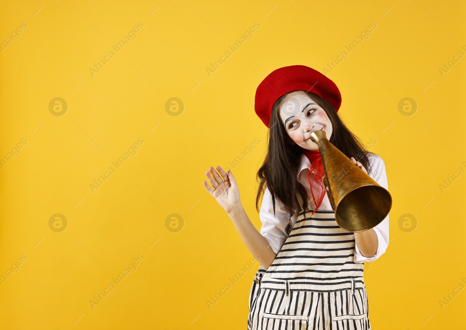 Photo of Cute girl dressed like mime with megaphone on yellow background, space for text. Surprise party