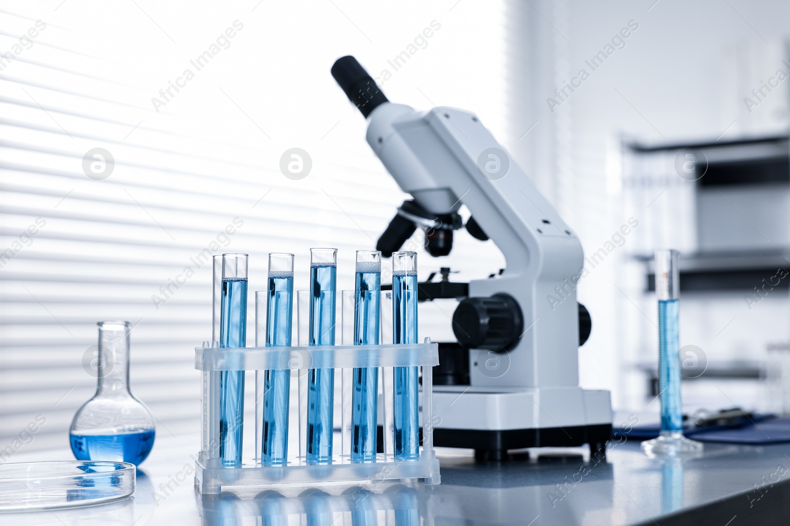 Photo of Chemical glassware and microscope on table in laboratory