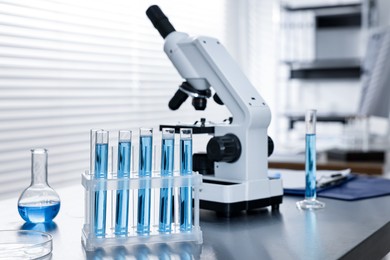 Photo of Chemical glassware and microscope on table in laboratory