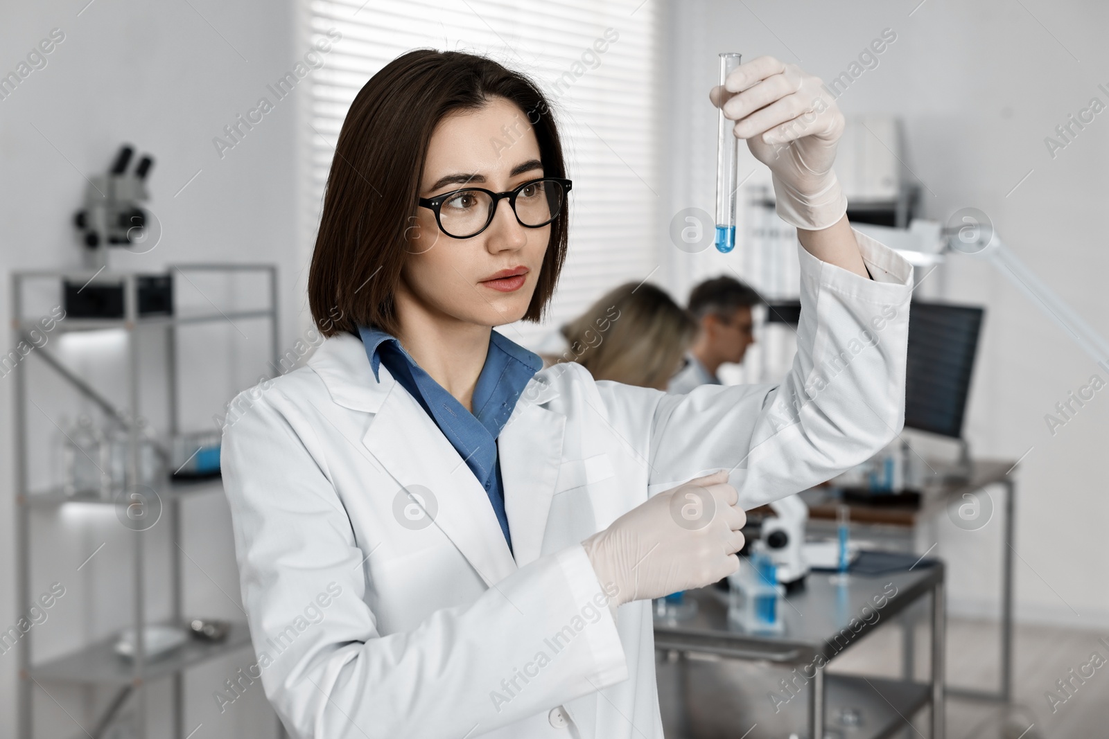 Photo of Scientist with test tube working in laboratory