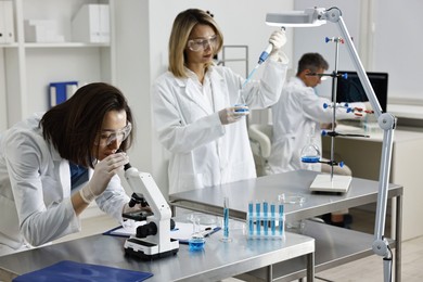 Photo of Scientists working with samples at table in laboratory