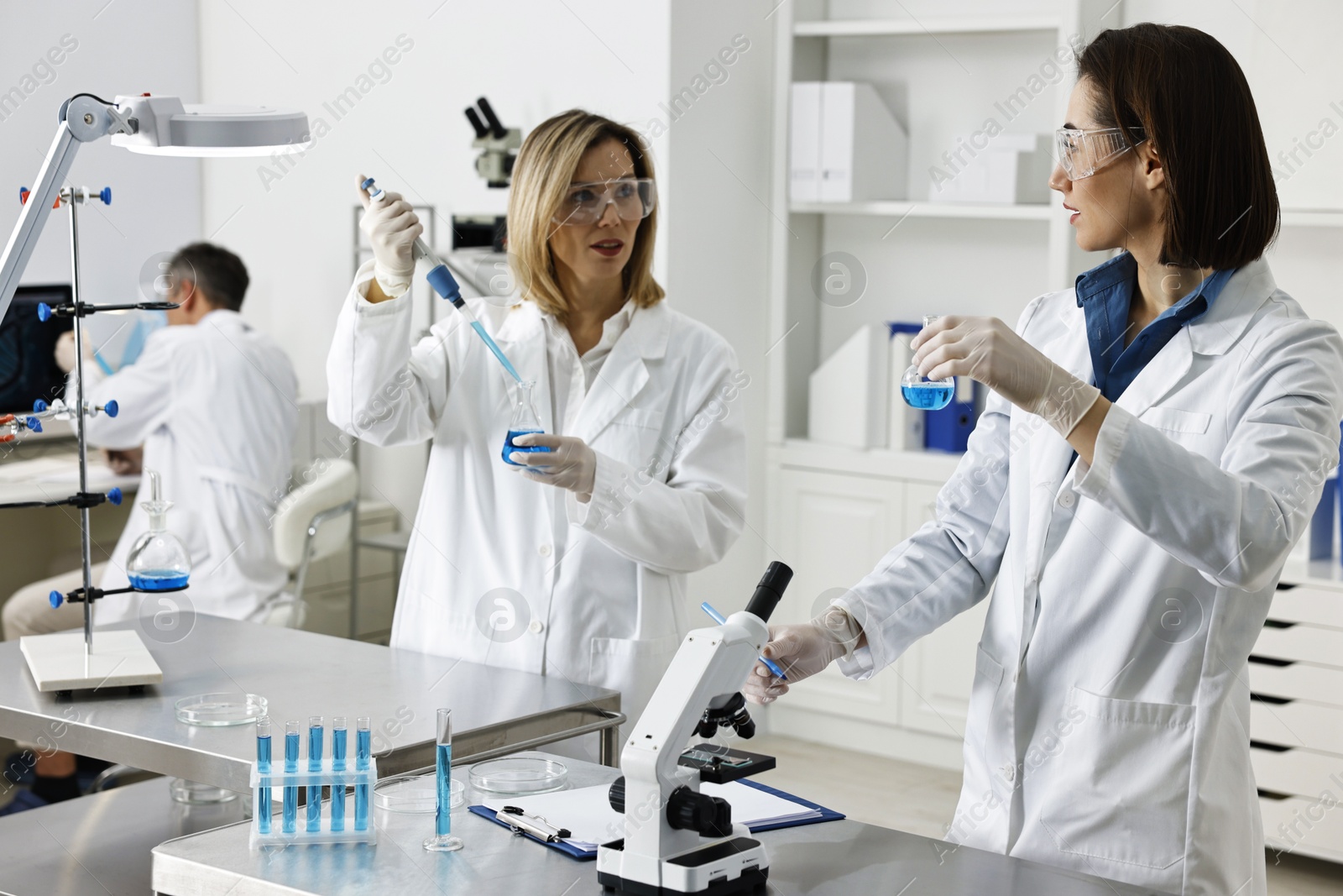 Photo of Scientists working with samples at table in laboratory