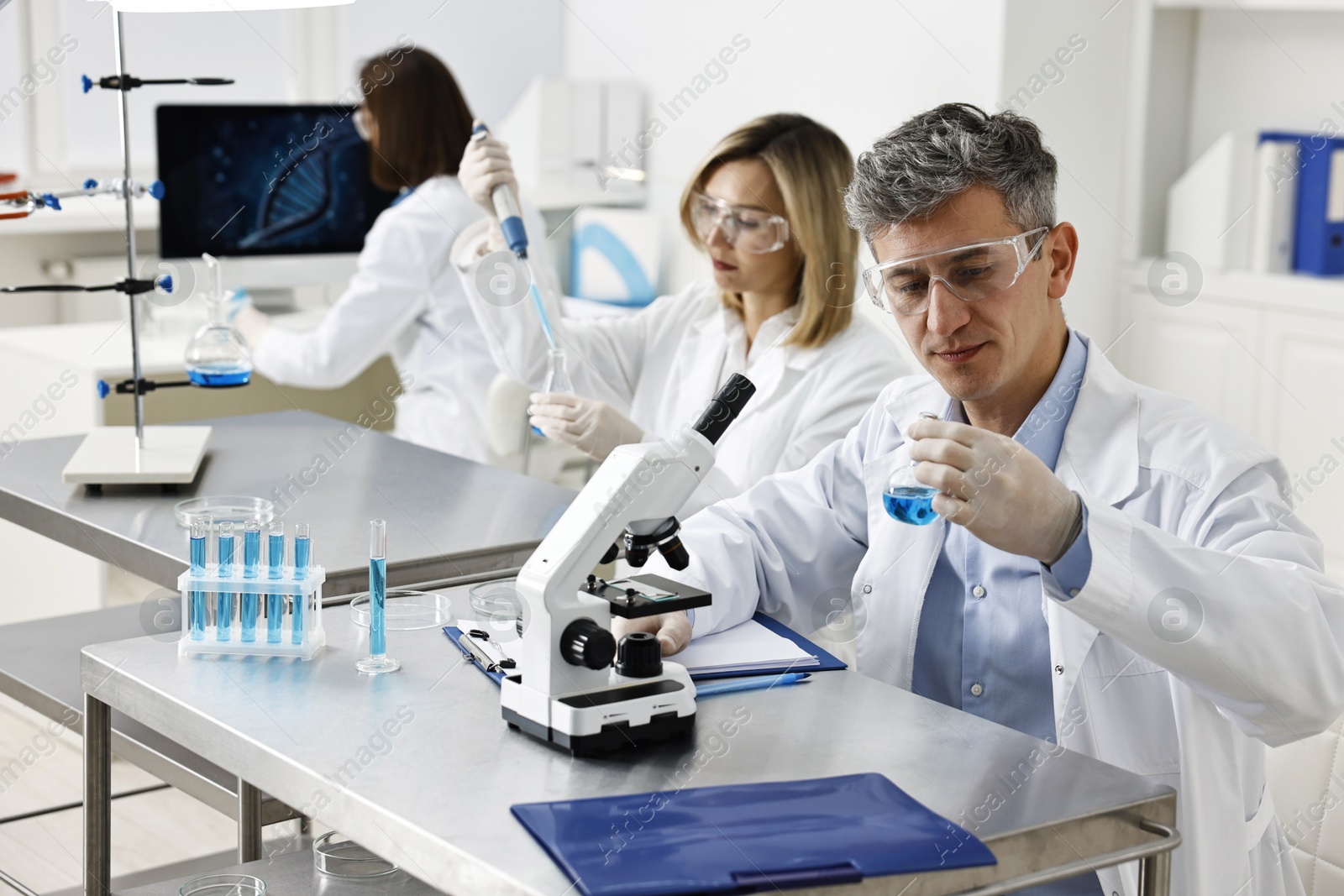 Photo of Scientists working with samples at table in laboratory