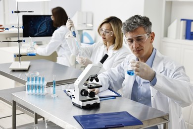 Scientists working with samples at table in laboratory