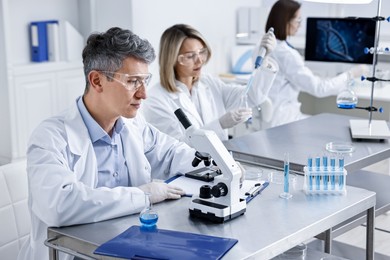 Scientists working with samples at table in laboratory