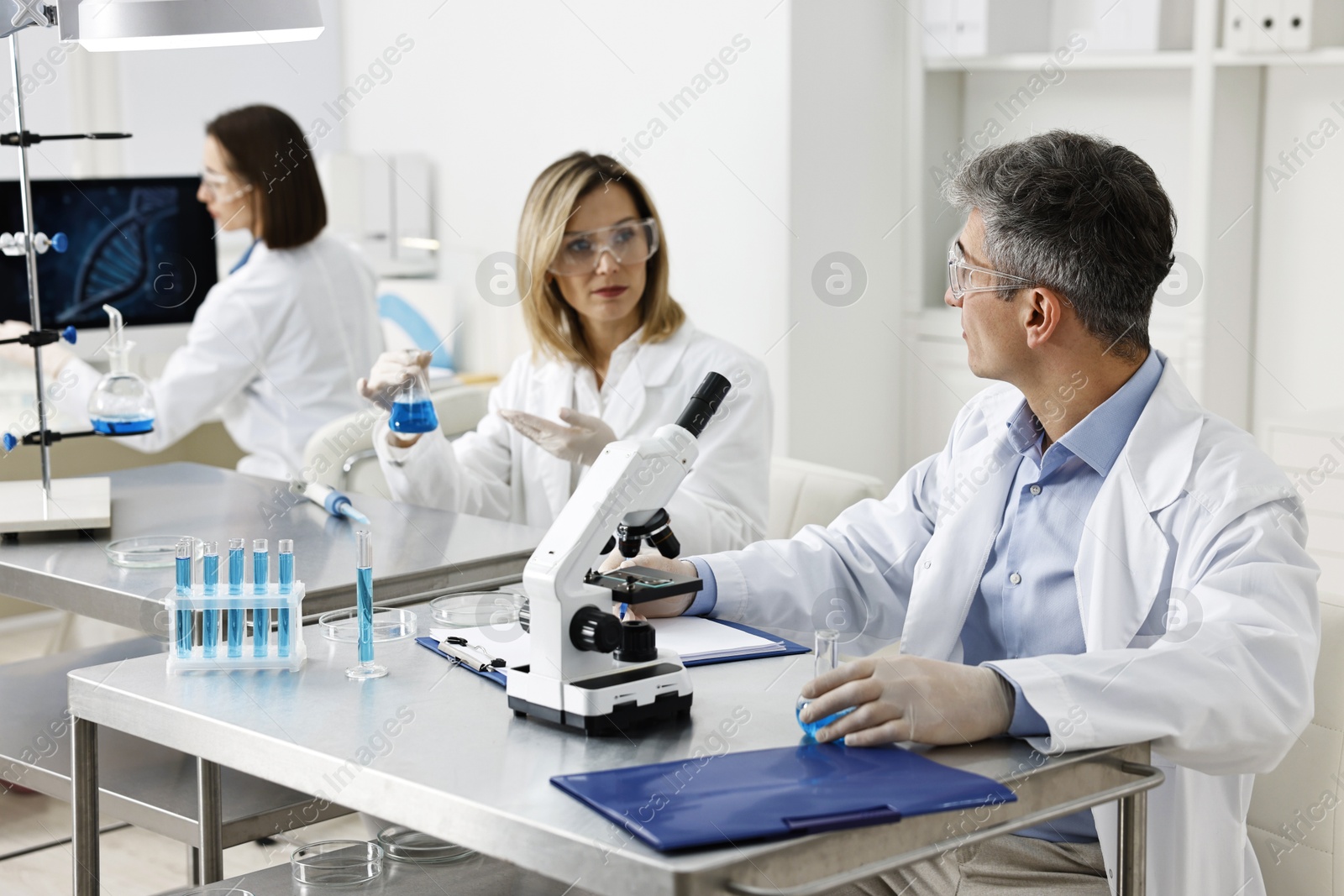 Photo of Scientists working with samples at table in laboratory