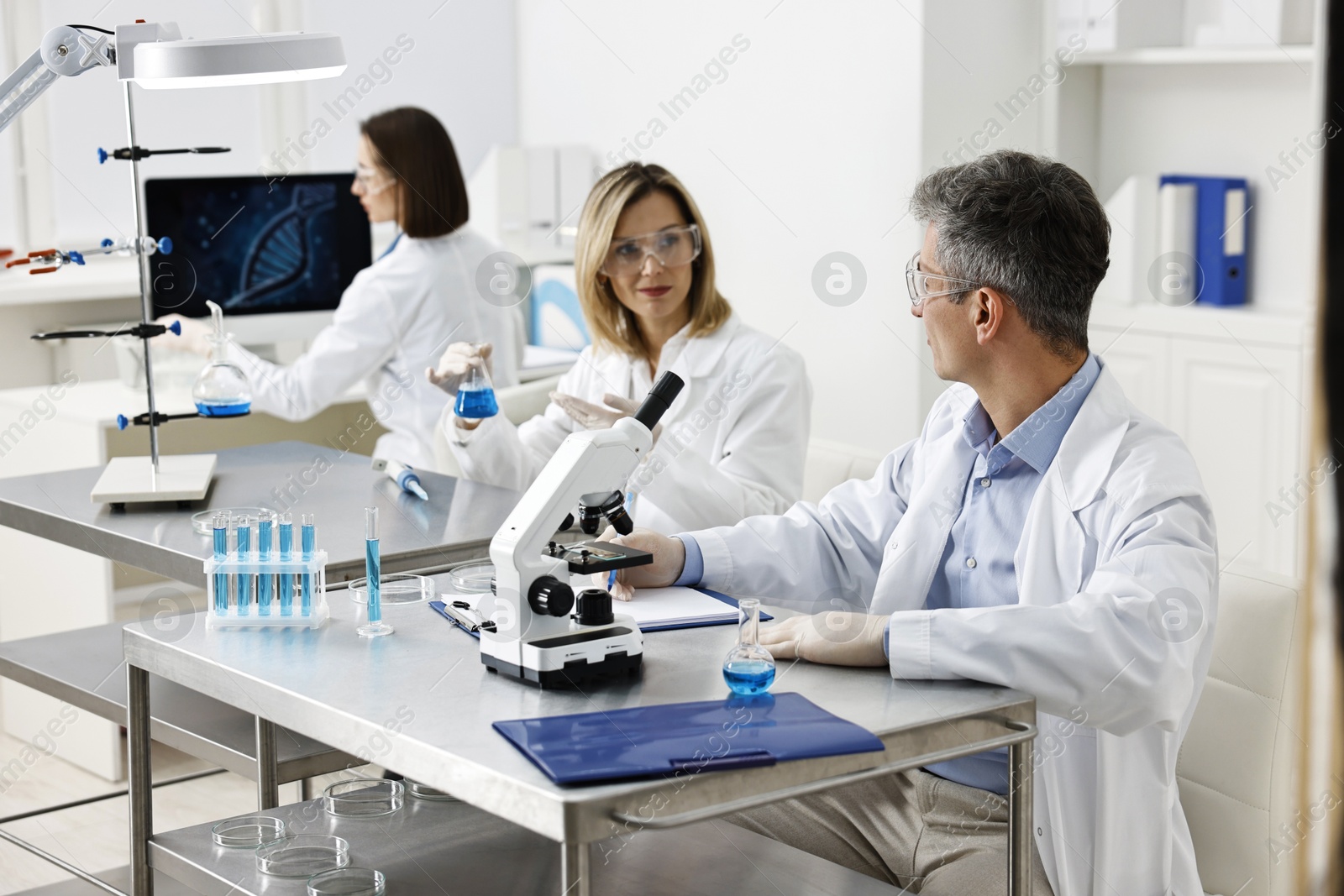 Photo of Scientists working with samples at table in laboratory