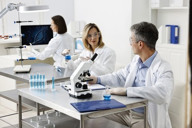 Photo of Scientists working with samples at table in laboratory