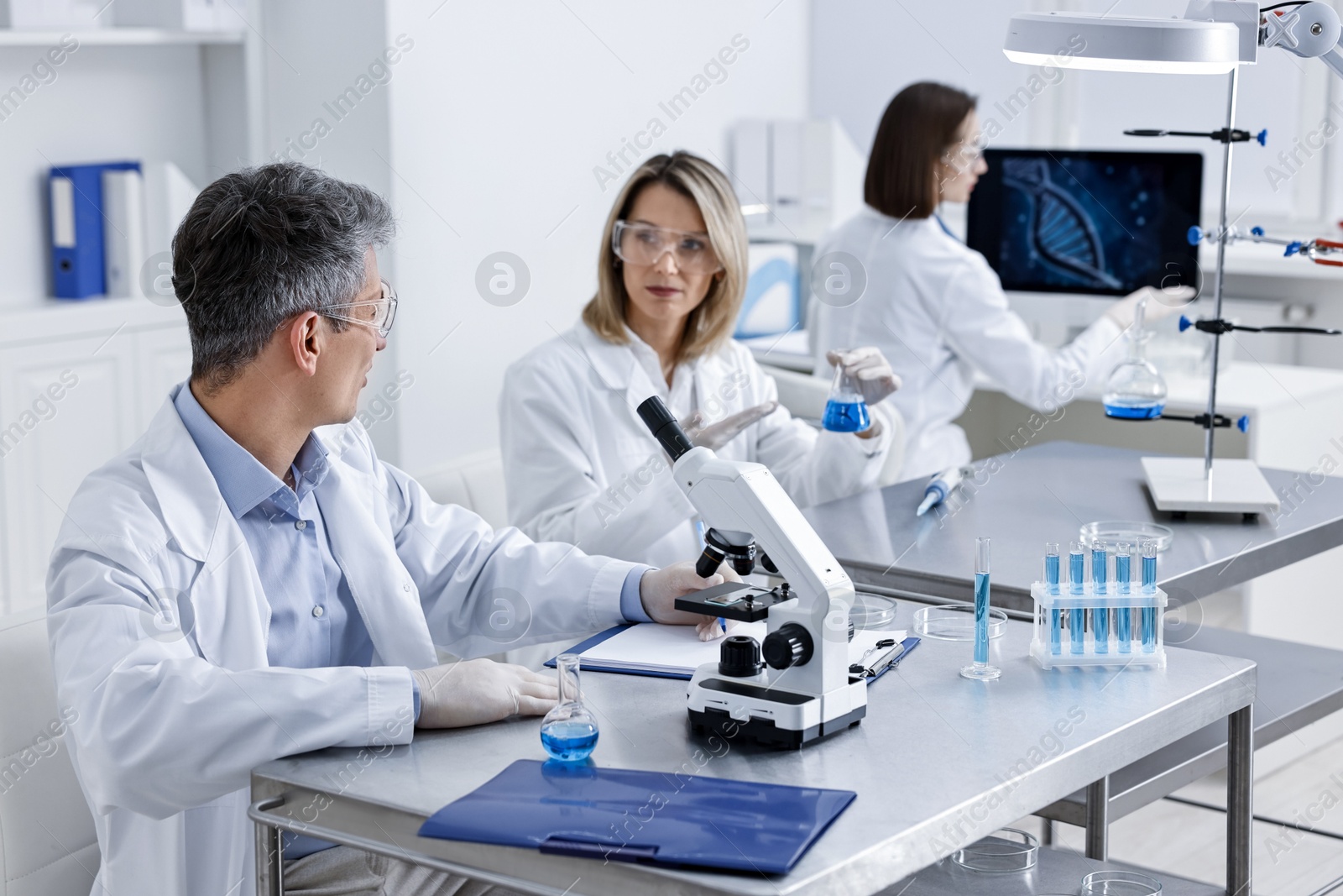 Photo of Scientists working with samples at table in laboratory