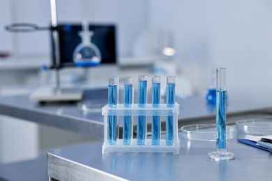 Photo of Test tubes with blue liquid on table in laboratory