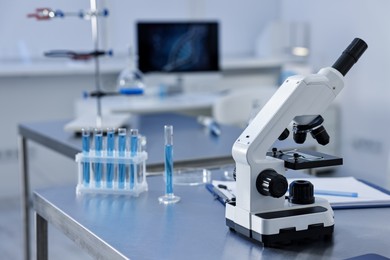 Photo of Chemical glassware and microscope on table in laboratory