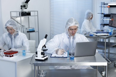 Photo of Scientists in protective suits working at laboratory