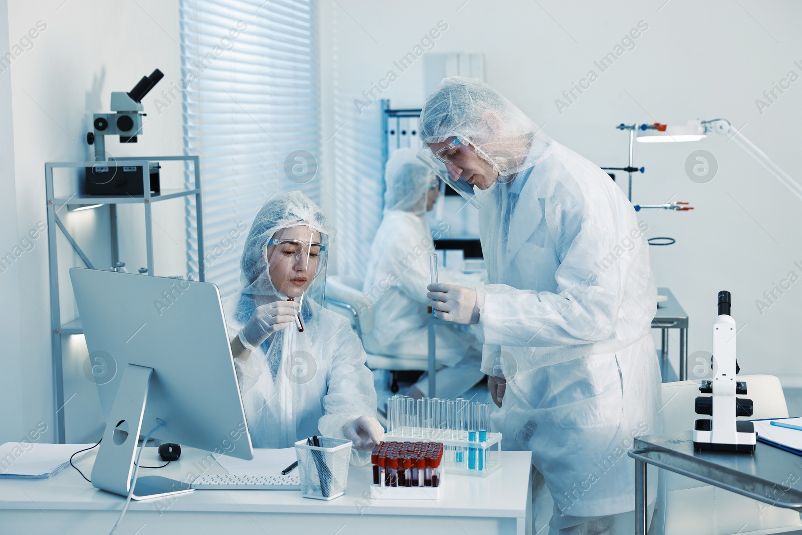 Photo of Scientists working with reagents and blood samples in laboratory