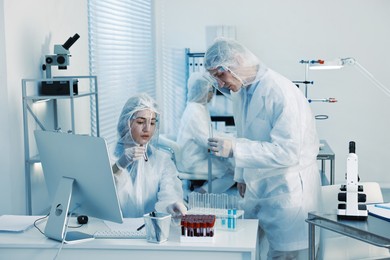 Scientists working with reagents and blood samples in laboratory