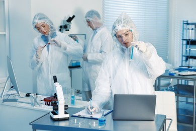 Scientists working with computers and samples in laboratory