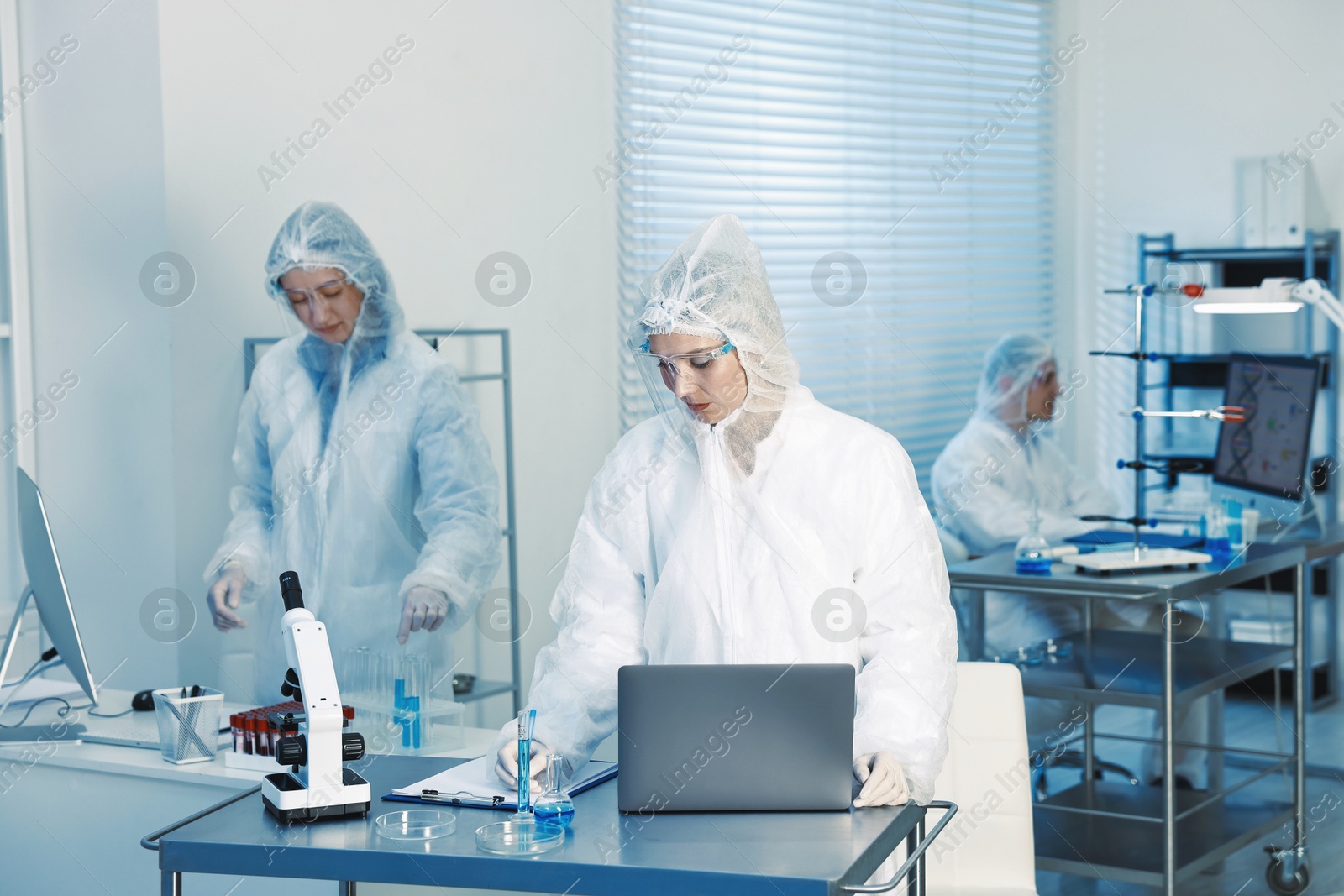 Photo of Scientists working with computers and samples in laboratory