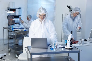 Scientists working with computers and samples in laboratory