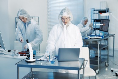 Photo of Scientists working with computers and samples in laboratory