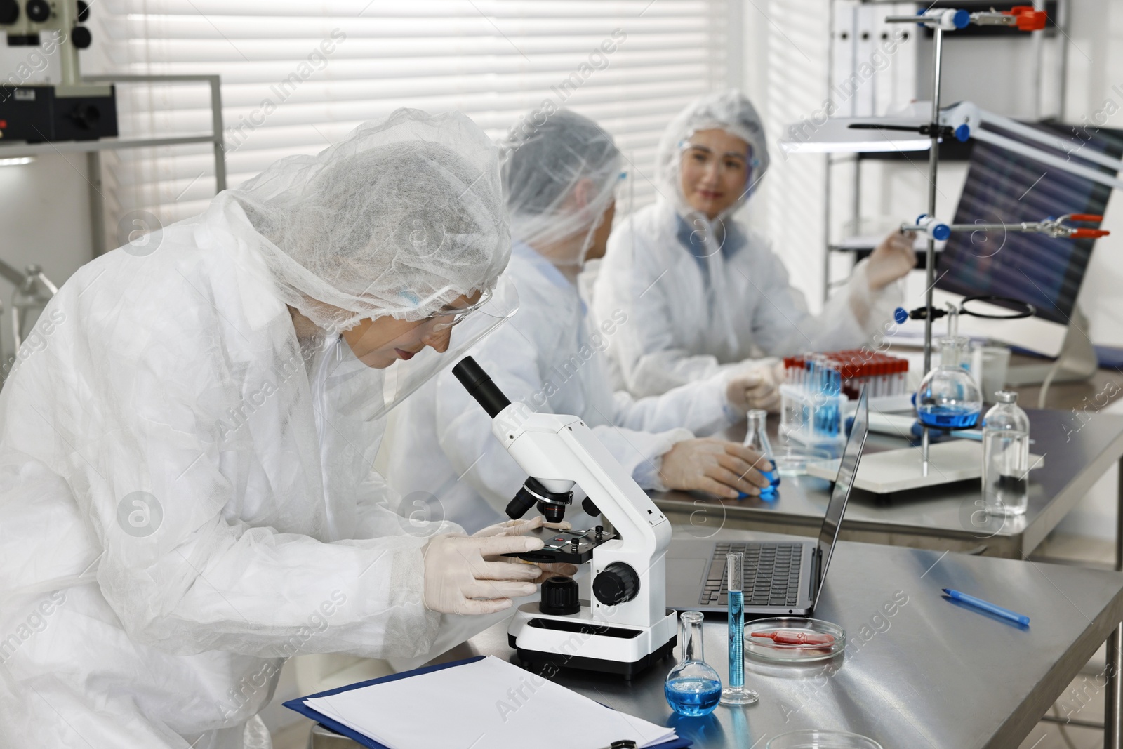 Photo of Scientist working with microscope at table in laboratory