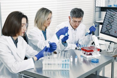 Photo of Scientists working with samples at table in laboratory