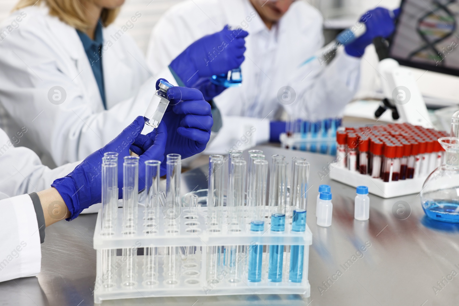 Photo of Scientists working with samples at table in laboratory, closeup