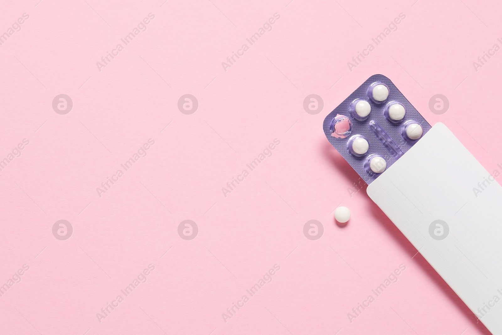 Photo of Blister of oral contraceptive pills on pink background, top view. Space for text